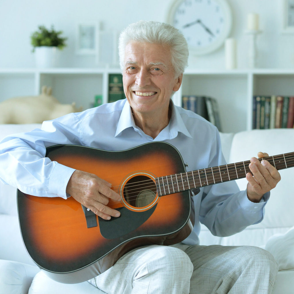 Idoso sorridente tocando violão