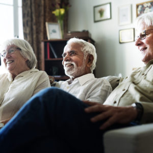 idosos sentados no sofá assistindo filme na ILPI