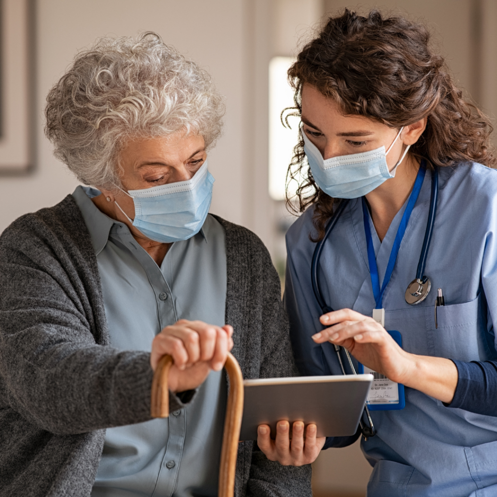 Enfermeira e mulher idosa usando tablet