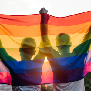 Casal homoafetivo com bandeira LGBTQIA+