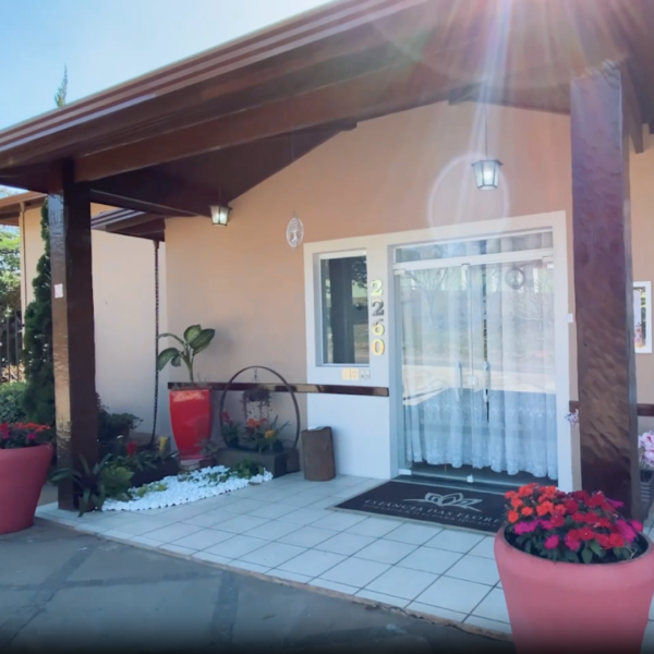 Entrada principal da Estância das Flores com varanda decorada e acessível.