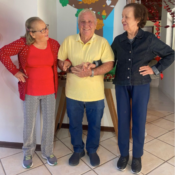 Três residentes da Estância das Flores participando de uma atividade social.