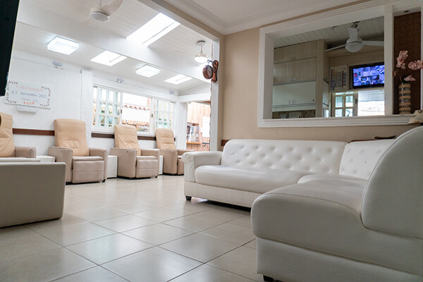 Sala de convivência com sofás confortáveis e iluminação natural, oferecendo acolhimento e bem-estar aos idosos.