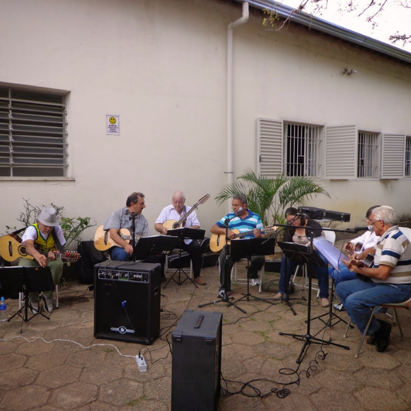 Residentes e voluntários participam de uma animada apresentação musical, promovendo integração e bem-estar dos residentes.