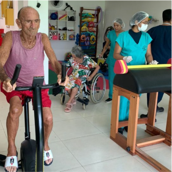 Residente participando de exercício físico em bicicleta ergométrica.