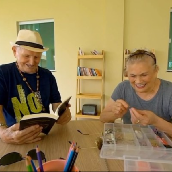 Residente da Estação Verde lendo enquanto outro faz artesanato, respeitando suas preferências.