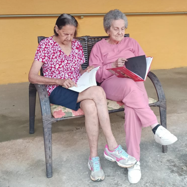 Duas senhoras lendo livros, sentadas lado a lado