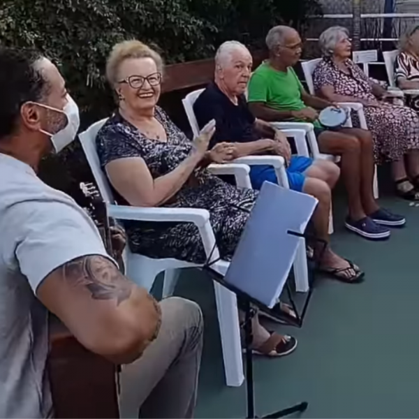 Músico tocando violão para idosos do Residencial Longévité