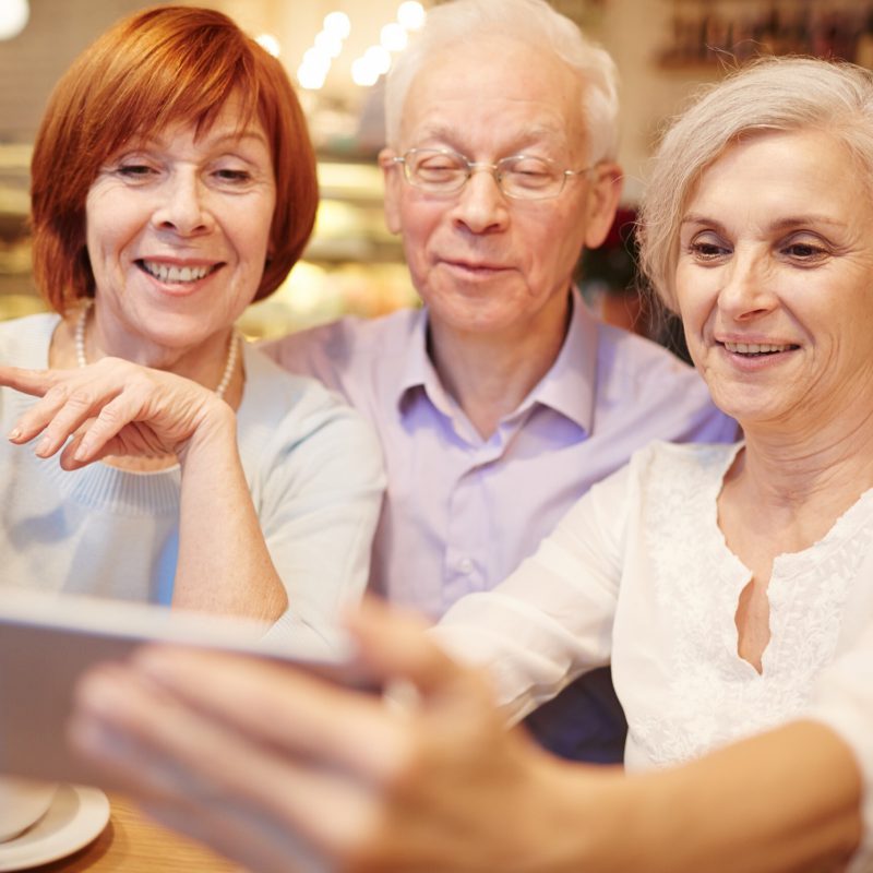 Row of smiling pensioners making their selfie in cafe during hangout